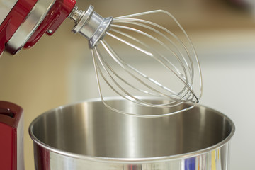 detail of the beater of a red tilt head stand mixer