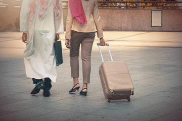 Fototapeta na wymiar Arab man and woman walking carrying a suitcase