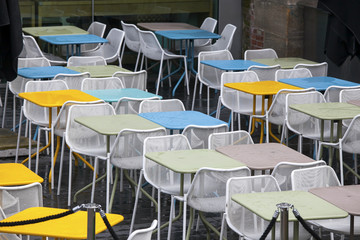 the Restaurant zone with colorful plastic chairs and blue, yellow, white tables in the lobby of the mall. Beautiful interior