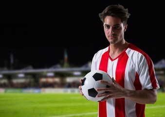 soccer player with the ball on his hands in the field at night