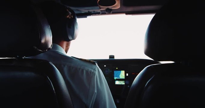 Pilot flying airplane. POV inside cockpit. Handsome young male professional pilot. Shot on RED