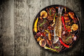 Fotobehang Bovenaanzicht van vers vlees en groente op grill geplaatst op houten vloer © Jag_cz