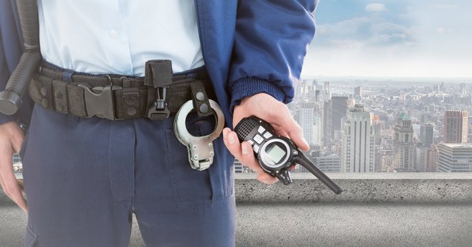 Security guard lower body with walkie talkie against skyline