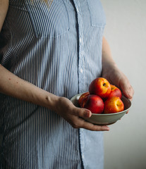 Woman holding fresh peaches. Summer Healthy food concept 