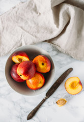 Ripe peaches in bowl on marble background