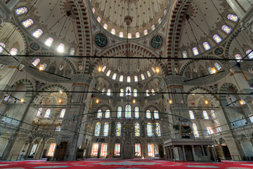Fototapeta na wymiar Fatih Mosque, a public Ottoman mosque in the Fatih district of Istanbul, Turkey, with a huge arches, decorated domes and colored stained glass windows