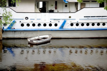 White boat moored to a board passenger vessel