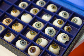 Prosthetic eyes with pupils of different colors on the stand. Medicine