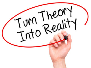 Man Hand writing Turn Theory Into Reality with black marker on visual screen