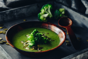 Broccoli cream soup with pumpkin seeds. Dark  wooden background
