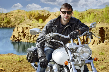 Biker man in black leather jacket sitting on motorcycle