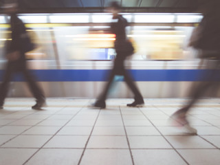 Subway train leaving station. People coming to or leaving the platform. Motion blur. City...