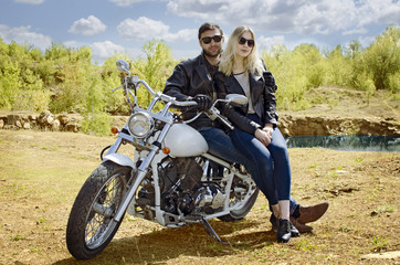 Naklejka na ściany i meble Biker man and blonde girl sitting on motorcycle