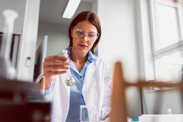 Woman scientist carrying out experiment in research laboratory