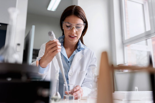 Woman scientist carrying out experiment in research laboratory