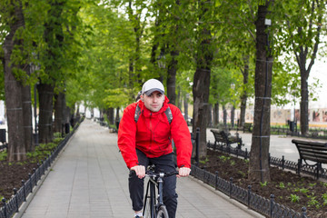 Obraz premium portrait of young man in red jacket riding on bicycle