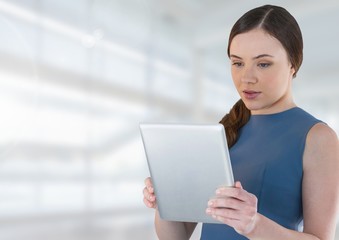 Fototapeta premium Businesswoman holding tablet in bright space hall