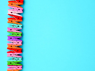 many colored clothespins on a blue background, as a substrate, pin clothes peg