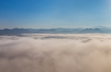 Fototapeta na wymiar High angle view over tropical mountains with white fog in early morning in Thailand.
