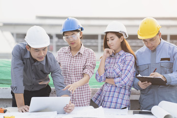 Asian engineers were consulted together and plan in construction site
