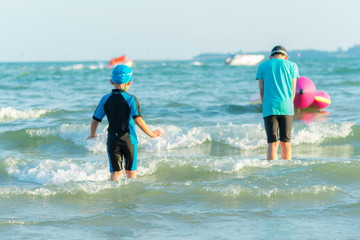 Two boy playing and looking waves  want to swim.