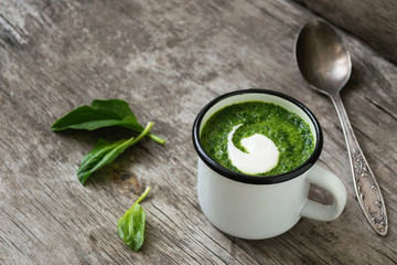 Fresh homemade cream soup of spinach poured into a white mug