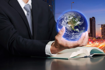 Businessman hand hold the Earth on light trails street city in the night as business, control and Saving World concept. Elements of this image furnished by NASA