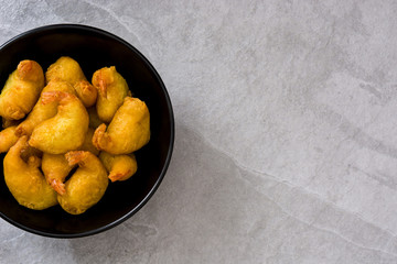 Deep fried shrimps in a bowl on gray stone
