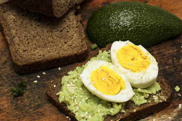 Avocado toast with egg whites on wooden board