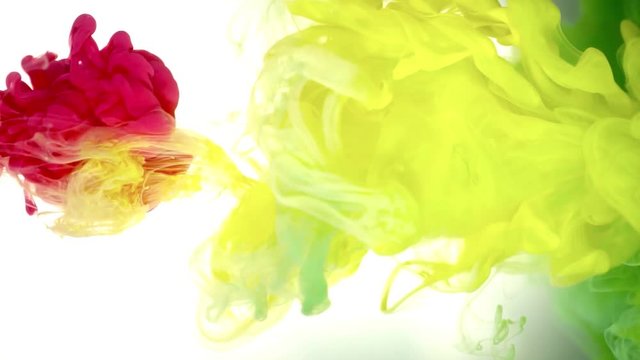 Ink of yellow, green and red color pouring into water on white background texture