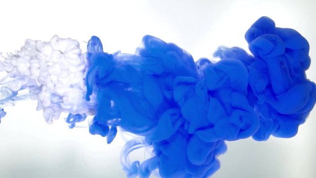Ink of deep blue color pouring into water on white background texture