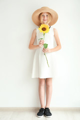 Attractive girl in straw hat with sunflower on white background