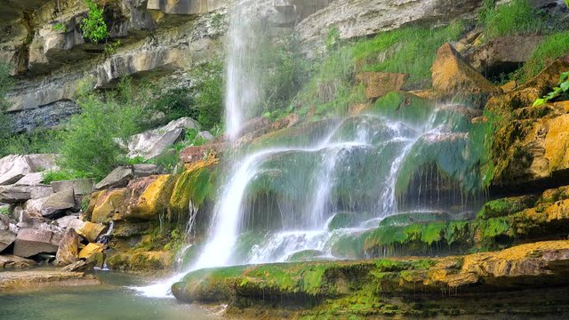 Waterfall falling on musky rocks