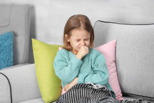 Small ill girl on couch at home