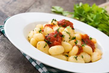 Gnocchi with tomato sauce on wooden background
