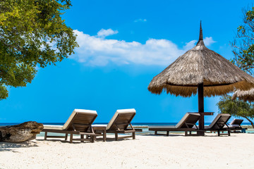 Rear View of Tropical Beach Chairs and Parasol Against Sea and Sky