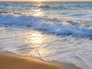 Waves on a sunny sunset beach