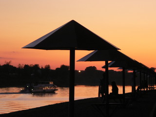 Embankment. Umbrellas on the sunset background