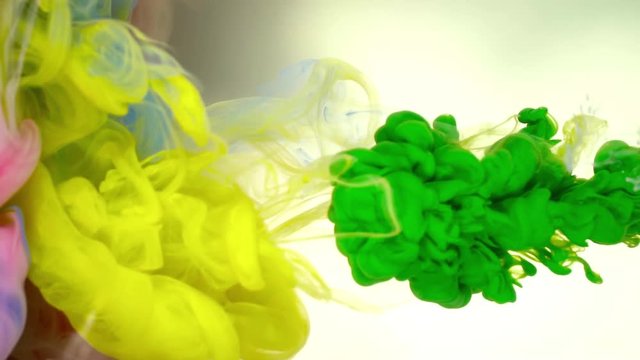 Ink of green and yellow olor pouring into water on white background texture