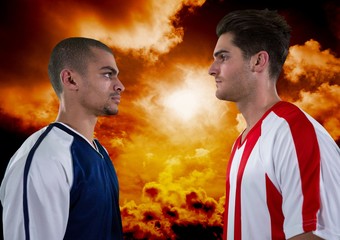 Soccer players looking each other with orange sky background