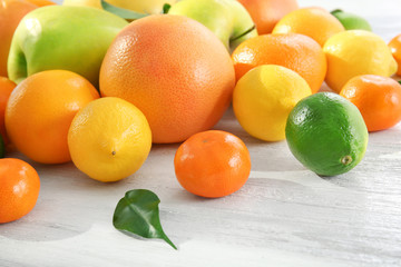 Appetizing fresh citrus fruits and apples on white wooden background