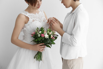 Gay wedding concept. Happy married lesbian couple on light background