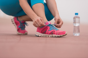 Young woman tying shoelaces on sneakers