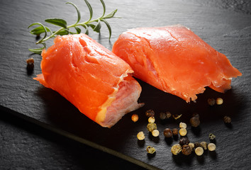 Roll slice of salmon, basil on black slate