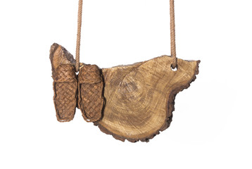 Bast shoes,Wooden board on ropes on white isolated background