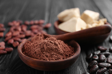 Wooden bowl with cocoa powder on table