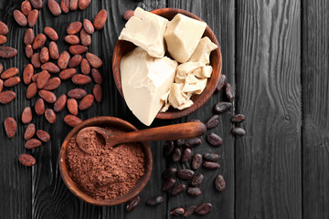 Bowls with cocoa butter and powder on wooden table