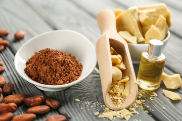 Composition with cocoa butter, products and cosmetics on wooden background