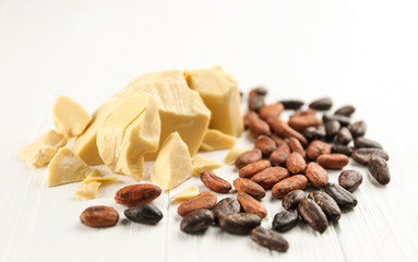 Composition with cocoa butter and beans on wooden background