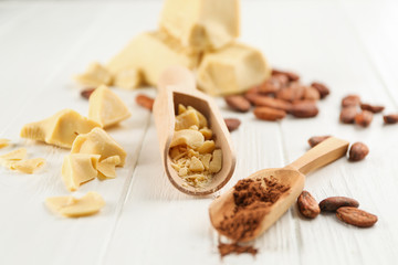 Composition with cocoa butter, powder and beans on wooden background